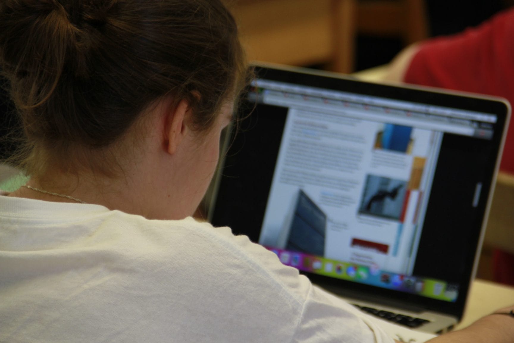 ne élève travaille sur un ordinateur portable dans une école numérique, utilisant des ressources en ligne pour approfondir ses connaissances et favoriser un apprentissage interactif.